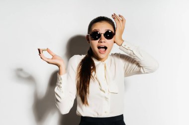 modern bir başarılı kız siyah güneş gözlüğü altın bitcoin elinde tutar ve çok sürpriz görünüyor