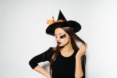 genç güzel kız cadı büyük siyah şapkalı, dokunmayacak saçları ve pozlar