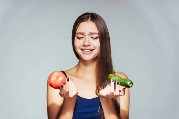 아름 다운 여자 다이어트에, 그녀의 손에 오 이와 토마토를 보유 하 고 그들을 먹고 싶지 않습니다. — 스톡 사진