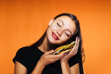 genç kız bir diyet oturur, zararlı bir burger ve gülümsüyor tutar