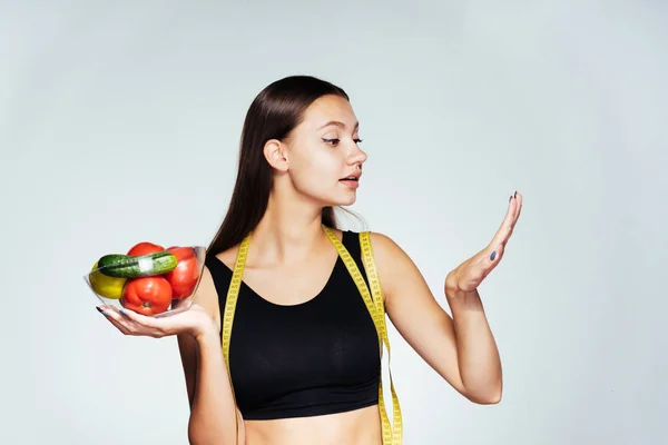 Krásná štíhlá dívka v černý top uchovává informace o její zdraví, drží desku s zeleniny a ovoce v dlaních a obdivuje její zdravé nehty — Stock fotografie
