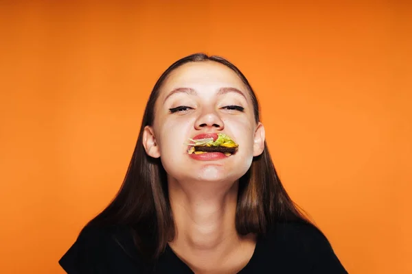 A young girl wanted to lose weight, but eats a big bad burger — Stock Photo, Image