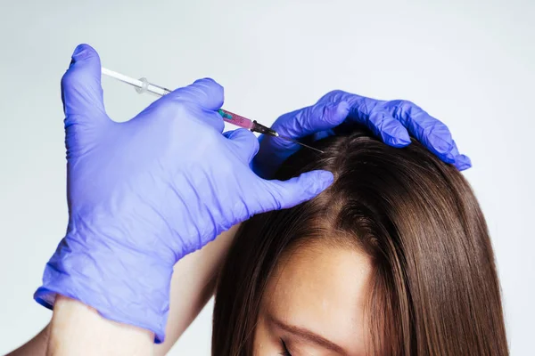 Uma jovem é dada uma injeção médica na cabeça para crescer e fortalecer o cabelo — Fotografia de Stock