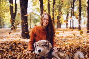 güzel gülen Kızıl saçlı kız düşmüş sonbaharda onun köpekle oynamayı bırakır
