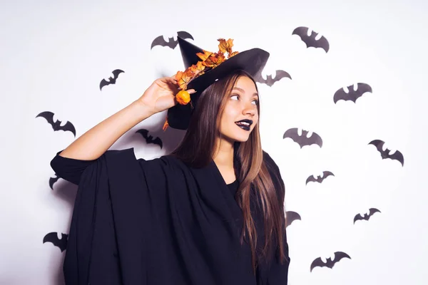 黄色の葉で飾られた頭の大きな黒の平手打ちに、ハロウィーンの魔女のイメージで美しいセクシーな女の子 — ストック写真