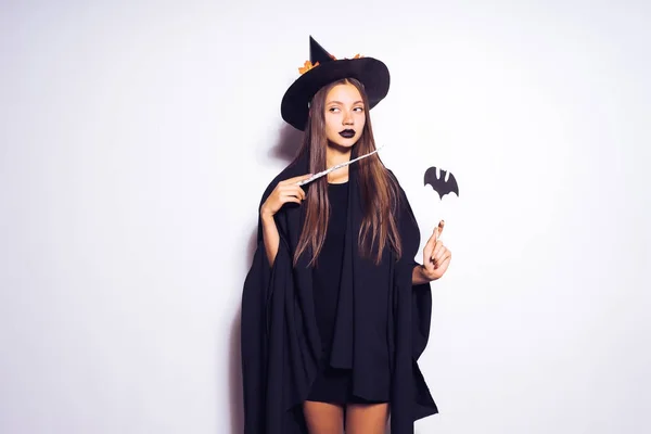 Beautiful gothic mysterious girl in the image of a witch holding a magic wand in her hand — Stock Photo, Image