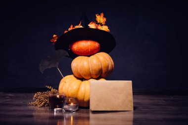 üzerinde Cadılar Bayramı, kabak stand üst üste, için evi dekore etmek için onları Kara Cadı şapkası ile dekore edilmiş yalan yaprakları sarı, mum yakmak, kurutulmuş çim yalan bir delikanlı