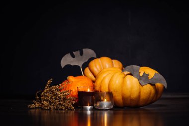 Sarı ve turuncu kabak, kokulu mumlar, yanan Cadılar Bayramı yalan bir atmosfer yaratmak için kuru ot ve çizimler siyah yarasa dalı yatıyor