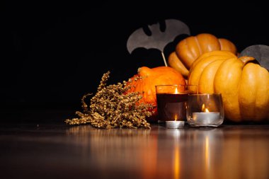 Sarı ve turuncu kabak, kokulu mumlar, yanan Cadılar Bayramı yalan bir atmosfer yaratmak için kuru ot ve çizimler siyah yarasa dalı yatıyor