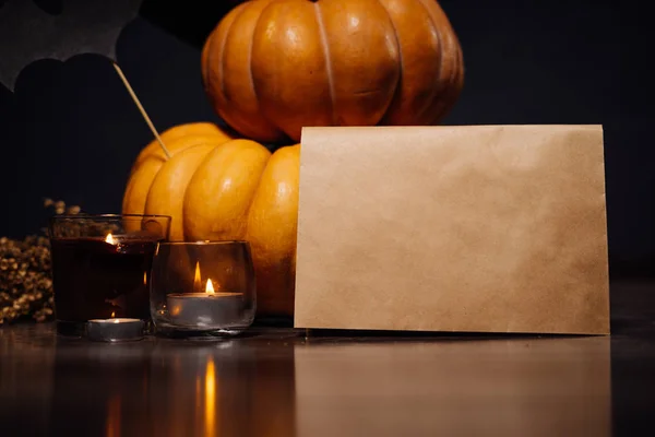 Chcete-li vytvořit atmosféru halloween lež žluté a oranžové dýně, vonné svíčky, leží větvička ze suché trávy a kraft papíru — Stock fotografie