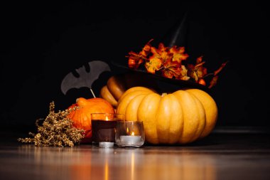 Sarı ve turuncu kabak, kokulu mumlar, yanan Cadılar Bayramı yalan bir atmosfer yaratmak için kuru ot ve çizimler siyah yarasa dalı yatıyor