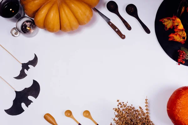 Op een witte tabel leugen oranje pompoenen, geurkaarsen, branden liggen houten lepels, herfstbladeren gele — Stockfoto