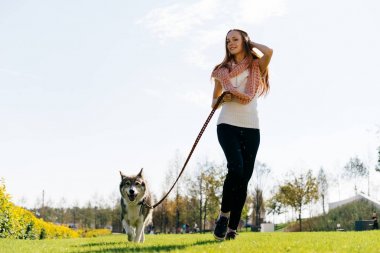 Bir kız köpeğini parkta yürüyor
