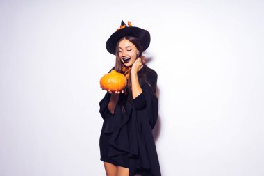 bir kız bir cadının elbiseli küçük bir kabak tutar