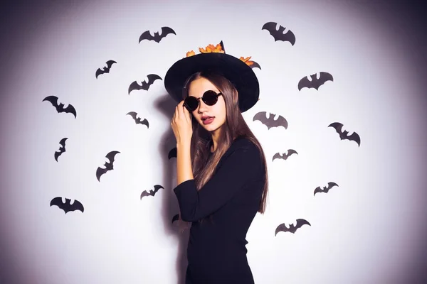 Meisje in een heks kostuum zwarte bril op een witte achtergrond — Stockfoto