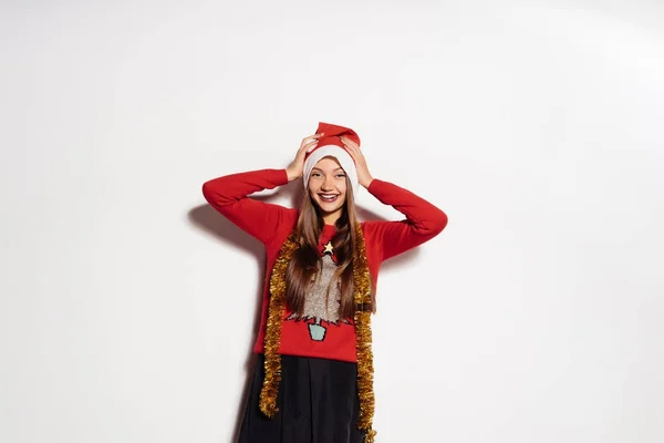 Das Mädchen im Neujahrsanzug zieht sich einen Hut über — Stockfoto