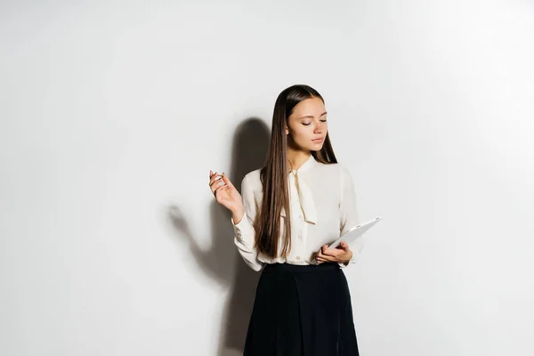 Mädchen im weißen Business-Hemd macht Notizen in Notizbuch — Stockfoto