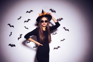 Kız bir cadı kostüm güneş gözlüğü takıyor yarasalar arka planı