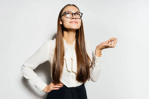 Una chica en una camisa de negocios y gafas es soñadoramente mirando hacia arriba — Foto de Stock