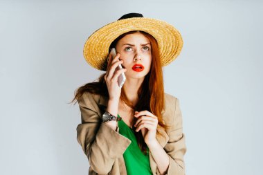 genç güzel kız hasır şapkalı ve telefonda konuşurken ve düşünceli yukarı seyir kırmızı ruj