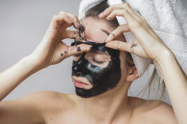 Kadın siyah maske, iyi sonuçlar çıkarmak. Yüz fırçalayın, pul pul dökülme gözenekleri, temiz cilt