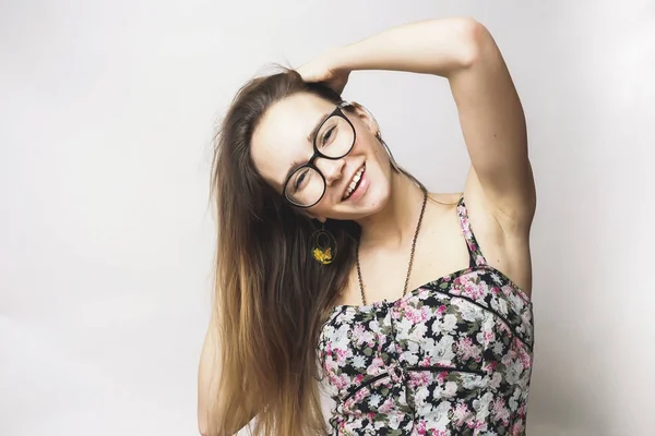 Pozytywne, młoda dziewczyna w okularach i sukienka obraz kwiaty uśmiechający się — Zdjęcie stockowe