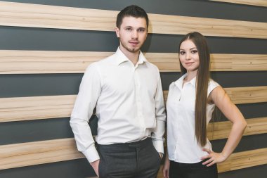 güzel başarılı adam ve office elbiseleri kız stand ve kameraya bak