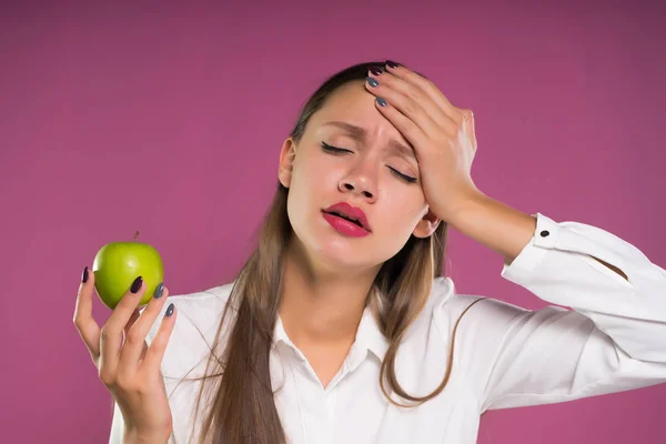 Szép fiatal lány szomorú gazdaság zöld alma, úgy néz ki, fáradt — Stock Fotó