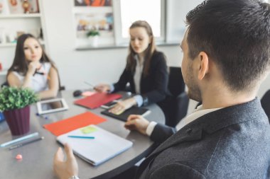 başarılı kendine güvenen adam ve 2 kız masa ve çalışma ofisinde oturuyor
