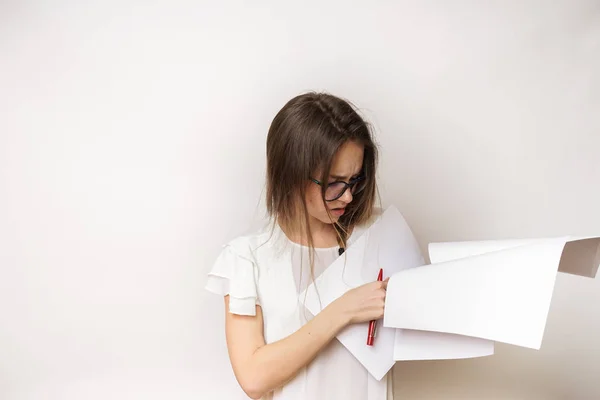 Ein junges Mädchen mit Brille und weißem T-Shirt hält eine Menge Dokumente in der Hand und sieht müde aus — Stockfoto