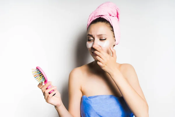 Молодая девушка с розовым полотенцем на голове, глядя в зеркало и выглядит недовольной — стоковое фото