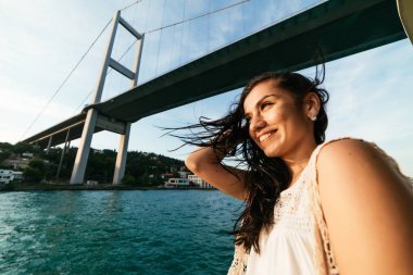 Genç özgürlük mutlu kız tekneyle modern köprü altında seyahat