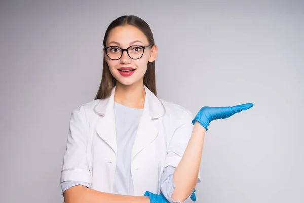 Alegre joven doctora con gafas y bata médica blanca sonriendo — Foto de Stock