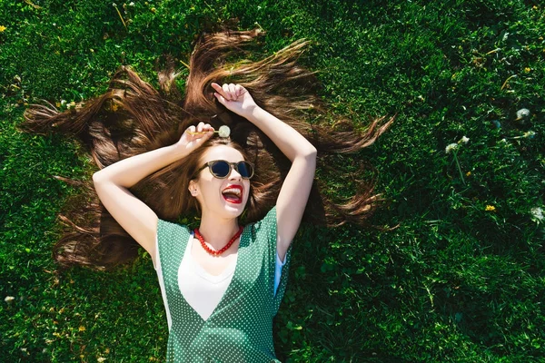 Ralxing kobieta młoda moda styl w parku, na trawie, widok powyżej, wolność — Zdjęcie stockowe