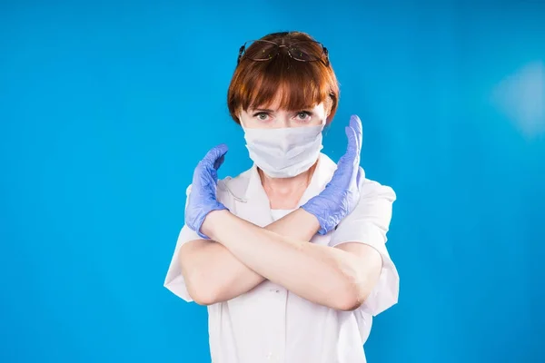 Vuxen kvinna läkare i skyddande mask visar stoppskylt med hjälp av händerna — Stockfoto