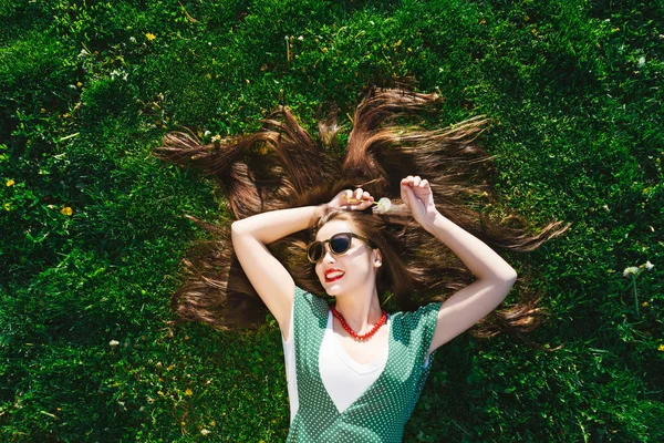 Ralxing jonge mode stijl vrouw in park, op gras, uitzicht boven, vrijheid — Stockfoto