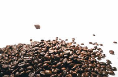 Beyaz bir arka plan üzerinde estetik açıdan güzel kokulu Brezilyalı kahve koyu kahverengi taneleri yalan