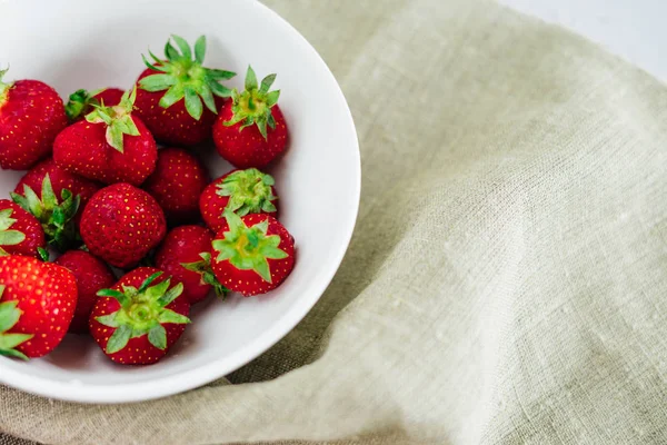 Verse rauwe gezonde voeding fruit van de aardbeien in plaat, geïsoleerd op wit, weergave boven, flatlay close-up, copyspace voor tekst, frame. Dorp rustieke doek, platteland voedsel — Stockfoto