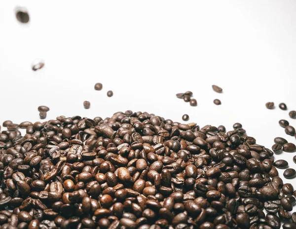 Hoş kokulu kahve koyu kahverengi taneleri beyaz yüzeyinde yalan — Stok fotoğraf