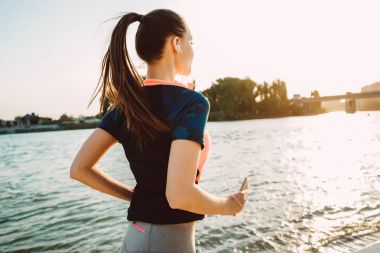 Kulaklığımda nehrin yanında ince fitness spor giysileri kızı çalışır