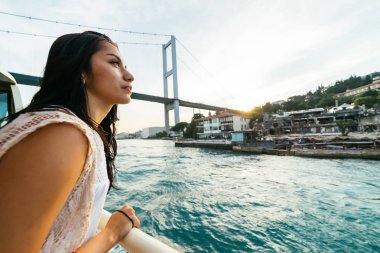 Sürpriz, tekne turu boğaz, modern köprü şehirde meraklı genç kız bakar