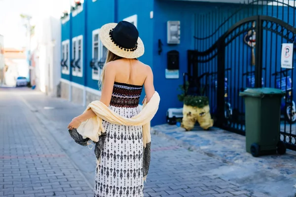 Mujer en la calle, vista trasera en sombrero, junto a la pared azul —  Fotos de Stock