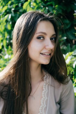 sevimli çekici kız gülümseyerek, kameraya bakarak bej elbise