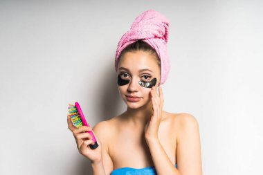 Kafasındaki bir tarak elinde pembe bir havlu ile temiz cilt ile genç şirin kız kameraya doğru seyir