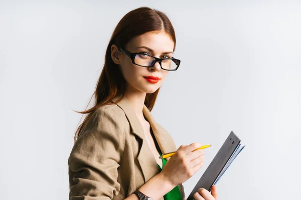 Stylisches Mädchen mit Brille und rotem Lippenstift hält einen Ordner mit Dokumenten und Stift in der Hand — Stockfoto