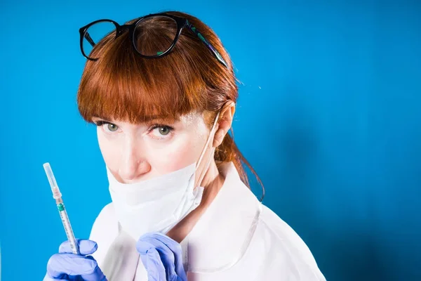 Médico adulto experimentado en máscara médica protectora sostiene la jeringa — Foto de Stock