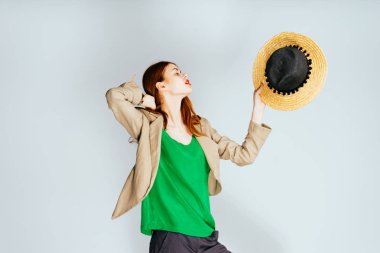 Kızıl saçlı kız parlak ruj yeşil bir bluz şapka onun elinde tutan ve kafasını yukarı yükseltir