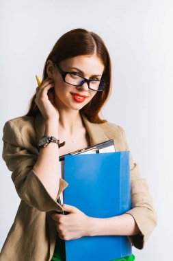 güzel kızıl saçlı kız gözlüklü bir klasör koruyor ve gülümseyerek kameraya bakarak izole