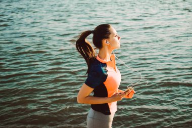bir eşofman bir kız nehir kıyısında dışarı fırladı ve müzik dinliyor
