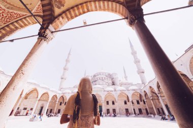 Caminin mavi arka plan üzerinde başörtüsü duran genç kadın gezgin. Yaz tatillerinde seyahat